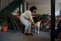 Female student in glasses feed the dog in cafe