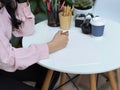 Female student hand drawing on mock up paper on coffee table in cafe Royalty Free Stock Photo