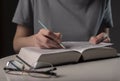 Female student hands holding pencil and reading book, prepare for exam at table at night. Education concept Royalty Free Stock Photo