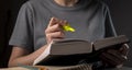 Female student hands holding yellow highlighter and reading book or textbook, making notes, underlines, prepare for exam Royalty Free Stock Photo