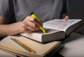 Female student hands holding yellow highlighter and reading book or textbook, making notes, underlines, prepare for exam Royalty Free Stock Photo