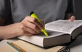 Female student hands holding yellow highlighter and reading book or textbook, making notes, underlines, prepare for exam Royalty Free Stock Photo