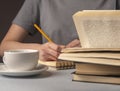 Female student hands underline information in book, prepare for exam, cup of tea or coffee, holding pencil. Education Royalty Free Stock Photo