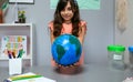 Female student holding a handmade globe world at ecology classroom