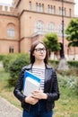 New study year begin. Female student holding notebooks outdoors and smiling on Uni background Royalty Free Stock Photo