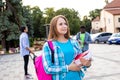 The female student is holding a stack of books outdoors Royalty Free Stock Photo