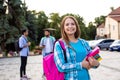 The female student is holding a stack of books outdoors Royalty Free Stock Photo
