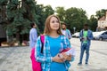 The female student is holding a stack of books outdoors Royalty Free Stock Photo