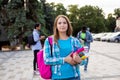 The female student is holding a stack of books outdoors Royalty Free Stock Photo