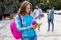 The female student is holding a stack of books outdoors Royalty Free Stock Photo