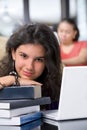 Female student leaning on books' pile Royalty Free Stock Photo