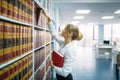 Female student looking book at the shelf, library Royalty Free Stock Photo