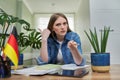 Female student looking talking to webcam, studying German online