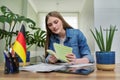 Female student looking talking to webcam, studying German online