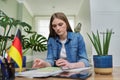 Female student looking talking to webcam, studying German online