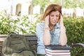 Female Student Outside with Headache Sitting with Books and Back Royalty Free Stock Photo