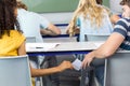 Female student passing note to friend in classroom