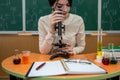 female student is practicing in a chemistry classroom with flasks on of a board with formulas. Royalty Free Stock Photo