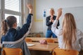 Female student raising hand and answering a teacher question Royalty Free Stock Photo