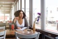 Female student sitting at cafe looking out of window daydreaming Royalty Free Stock Photo