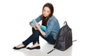 Female student sitting on floor with backpack reading a book Royalty Free Stock Photo