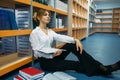 Female student sitting on the floor in library Royalty Free Stock Photo