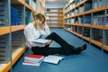 Female student sitting on the floor in library Royalty Free Stock Photo