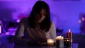 female student is studying at home at night, reading book with candlelight, tired and exhausted