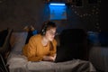 Female student studying at night on bed in dorm room using laptop computer Royalty Free Stock Photo