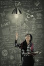 Female student switch on a light bulb Royalty Free Stock Photo