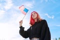 Female student teenager with USA flag in hand, blue sky with clouds background. Royalty Free Stock Photo