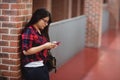 Female student using mobile phone in corridor Royalty Free Stock Photo