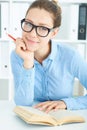 Female student at workplace with book holding red pencil studying. Education, self development and perfection concept