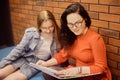 Female students sit in the corridor of the university / university dormitory and teach homework, lectures. The girl explains to