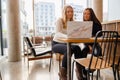 Female students work on common school project at coffee shop in city