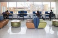 Female students working at computer stations by window showing bleak winter trees and buildings in student lounge at university