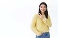 Female stylish asian healthy girl in yellow sweater, turn left and pointing advertisement, smiling pleased, recommend