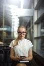 Female in stylish glasses and formal white shirt using messenger on cell telephone Royalty Free Stock Photo