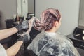 Female stylist applying a dye to the clients hair