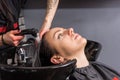 Female stylist washes off the shampoo of young woman in washing Royalty Free Stock Photo