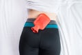 Female suffering from abdominal pain,Period cramps,Woman using hot water red bag or bottle on her back Royalty Free Stock Photo