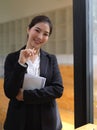 Female in suit holding schedule book and pen looking into camera in office room Royalty Free Stock Photo