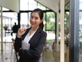 Female in suit holding schedule book and pen while standing in office room Royalty Free Stock Photo