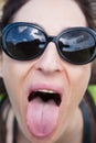 Female with sunglasses sticking out her tongue