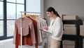 Female Supplier Checking Clothes In Storage Office