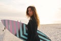 Female Surfer At The Beach Walking Down Jetty With Surf Board Or Kite Surfing Wearing Wetsuit Royalty Free Stock Photo