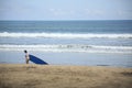 A female Surfer with surfing board walks in Kuta Beach Bali Island, Indonesia Royalty Free Stock Photo