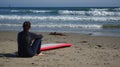 Female surfer contemplating waves