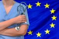Woman surgeon or doctor with stethoscope on the background of the European Union flag. Health care, surgery and medical concept in Royalty Free Stock Photo
