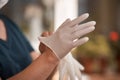 Female surgeon or nurse wearing a sterile suit putting on sterile rubber gloves to perform a surgery Royalty Free Stock Photo